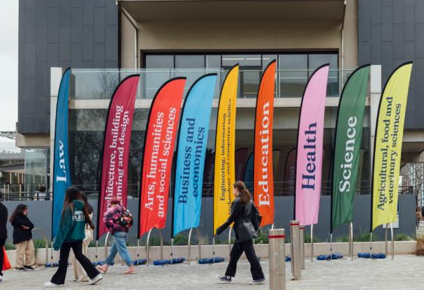 Tall banners on Parkville campus in different colours with names of study areas printed on them